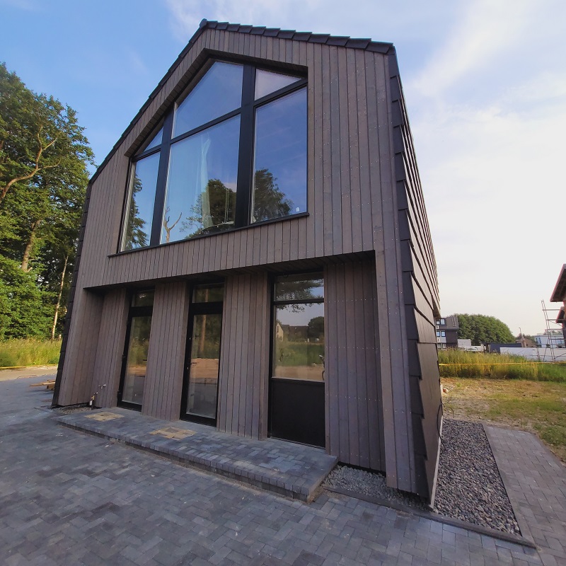 Fachada de casa moderna y luminosa con madera quemada